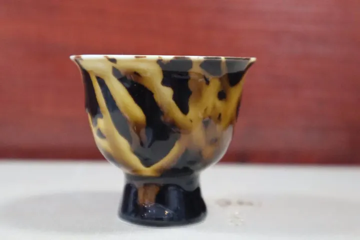 南窑草木灰玳瑁釉主人杯，黄褐与深色釉斑交融